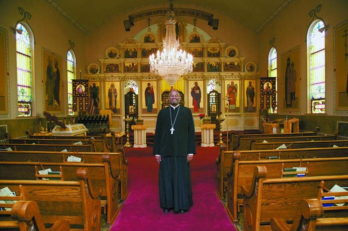 Malaysian native the Rev. John Edward stands in St. Michael's Orthodox Church, 131 N. Willow St., Mount Carmel, where he has been the priest for about one year.