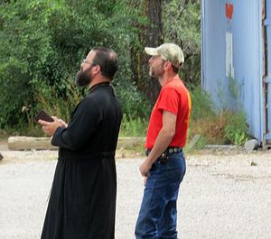 Fr. Theophan Mackey watches Friday as workers install the golden dome on top of his new chruch. Photo by Leland Lehman/ladailypost.com