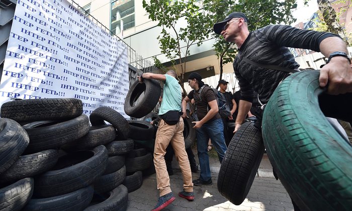  Activists throw tires as they block the entrance of the Inter TV channel in Kiev on the 5 September. Photograph: Sergei Supinsky/AFP/Getty Images