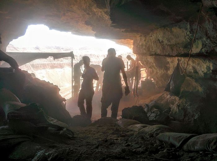 Volunteers and archaeologists working in the Cave of the Skulls, overlooking Nahal Tze’elim in the Judean Desert on June 1, 2016. (Ilan Ben Zion/Times of Israel staff)