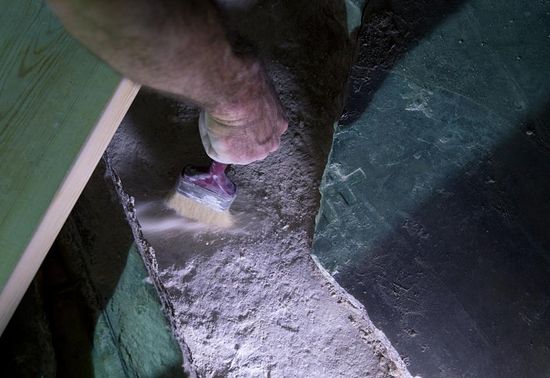 A restorer removes debris beneath a broken marble slab to expose the original rock surface of what is considered the burial place of Jesus. PHOTOGRAPH BY ODED BALILTY, AP FOR NATIONAL GEOGRAPHIC
