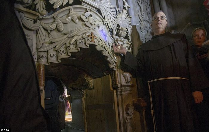 A Franciscan friar stands next to the tomb of Jesus Christ in the Church of the Holy Sepulchre in the old city of Jerusalem. The tomb has now been resealed and will probably not be opened again for hundreds, possibly even thousands, of years