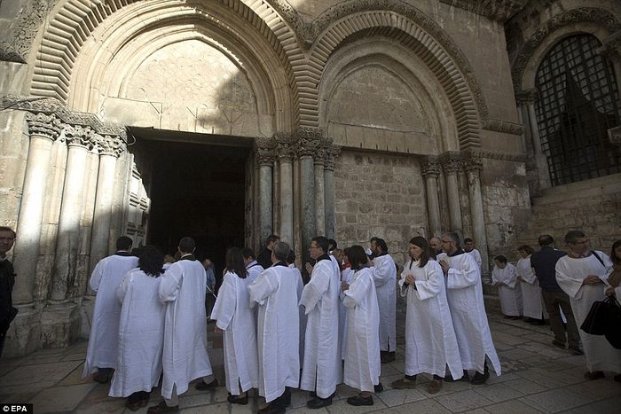 Christian pilgrims pray outside the Church of the Holy Sepulchre. Christian tradition says Christ's body was laid on a slab cut from a limestone cave after his crucifixion by the Romans
