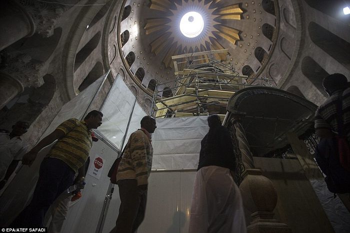 Christian pilgrims pass next to the tomb. National Geographic has been filming the work being done at the church, which is considered the most sacred site in Christianity