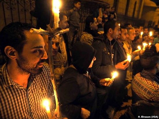 Egyptian Copts seen lighting candles during a vigil in front of the "Botrosia" church, 35 were announced injured in Abbassya as they attended a vigil in Cairo, Dec. 11, 2016.