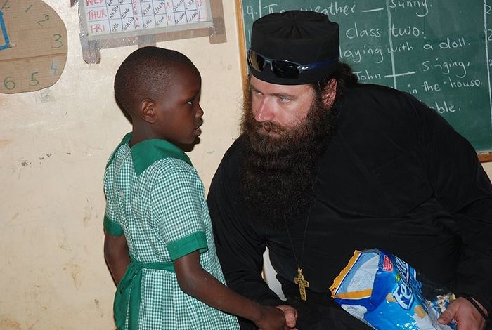 Отец Силуан общается с одним из детей Киберы в образовательном центре святого Георгия