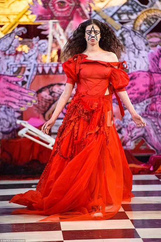 Эта модель одета в ритуальное красное платье, а на лице у нее – большая пентаграмма. Большинство моделей превратились в магические предметы, словно все это часть одного оккультного ритуала