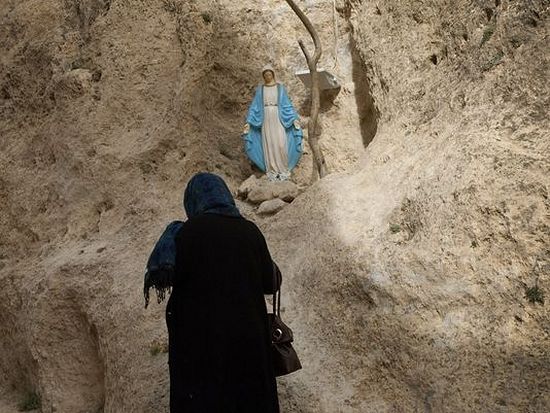 Женщина молится Пресвятой Богородице в Маалюле. Фото AFP