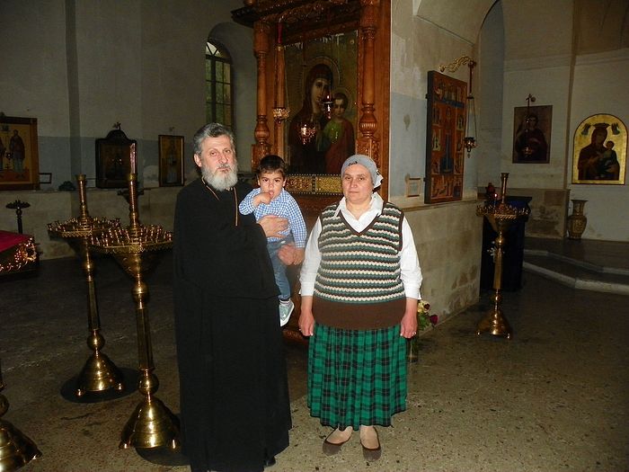 Протоиерей Феодор (Хуцишвили), матушка Нина и внук Георгий рядом с чудотворной Казанской иконой Пресвятой Богородицы